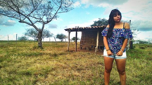 Full length of young woman standing on field