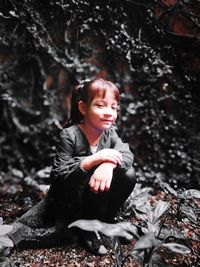 Portrait of smiling young woman in forest during winter