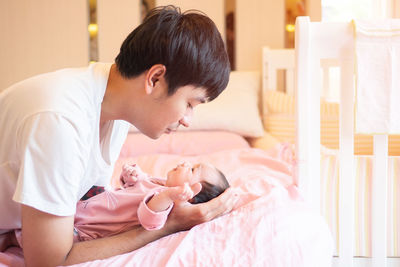 Young man with baby girl at home
