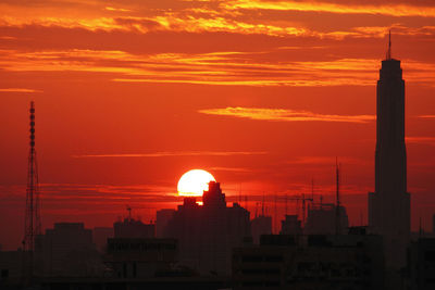 Silhouette buildings against romantic sky at sunset