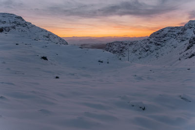 Scenic view of snowcapped mountains against sky during sunset