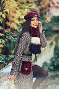 Smiling young woman wearing fashionable clothing outdoors