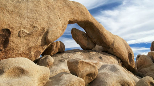 Rock formation by sea against sky