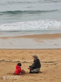 People sitting on beach by sea