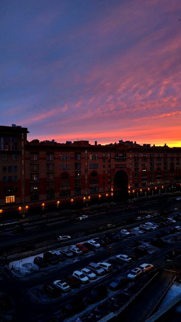 building exterior, architecture, sky, sunset, built structure, city, cloud - sky, building, no people, nature, mode of transportation, land vehicle, transportation, cityscape, dusk, car, outdoors, illuminated, high angle view, motor vehicle