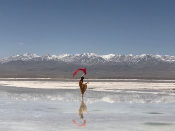 Full length of woman standing at beach against sky