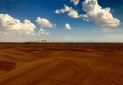 Scenic view of desert against cloudy sky