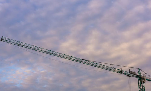 Low angle view of crane against sky at sunset