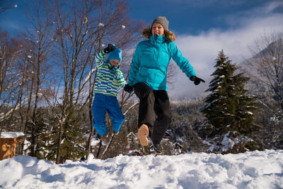 Full length of people on snow covered trees
