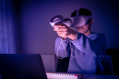 Teenager playing with virtual reality device. cyberpunk futuristic mood, video game and vr 3d viewer