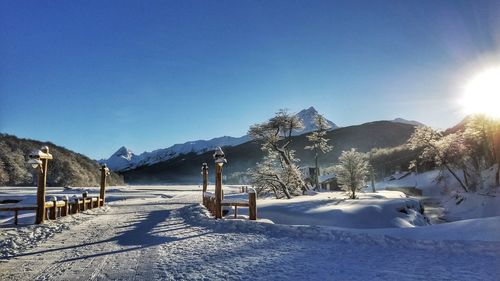 Scenic view of snow covered landscape against clear blue sky