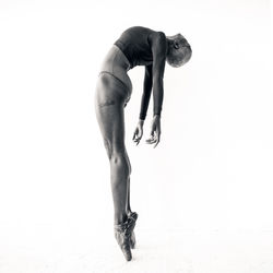 Side view full length of ballet dancer on white background