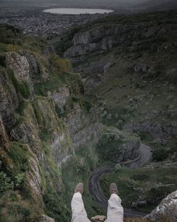 Low section of woman on road by mountain against sky