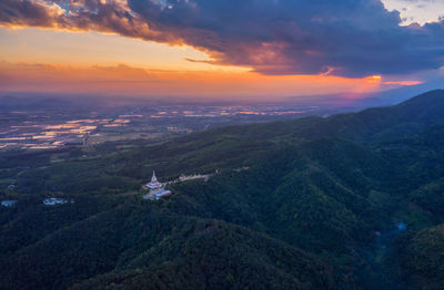 Aerial view of landscape and buildings against sky during sunset