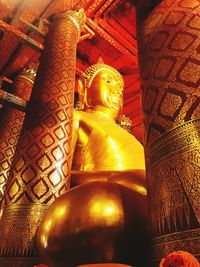 Low angle view of buddha statue against building