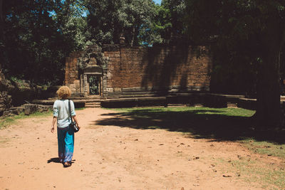 Rear view full length of woman walking towards temple