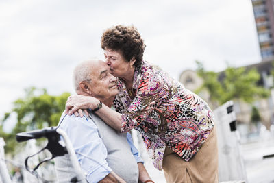 Senior woman kissing her husband