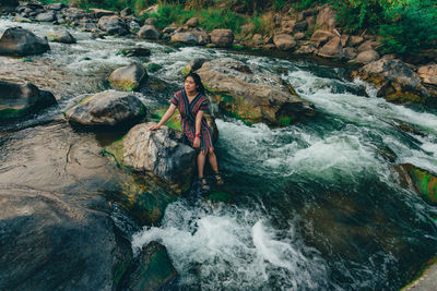 Man standing on rock by river