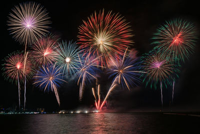 Firework display over river at night