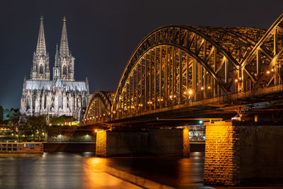 Illuminated bridge over river at night