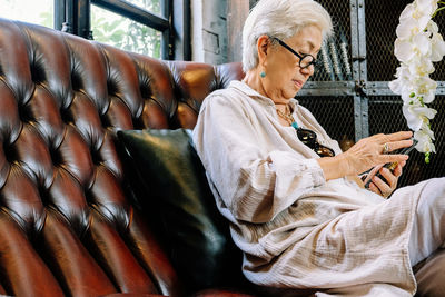 Close up image of senior woman using her mobile phone background. 