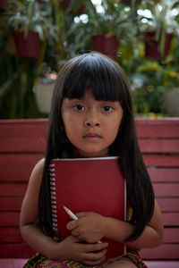 Portrait of a smiling girl sitting outdoors