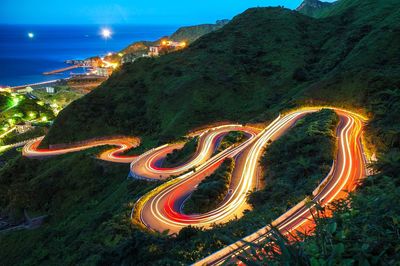 High angle view of light trails on road against sky at night