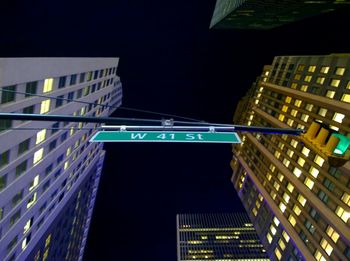 Low angle view of illuminated buildings against sky at night