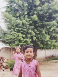 Portrait of smiling couple standing against trees