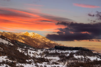 Scenic view of snowcapped mountains against sky during sunset