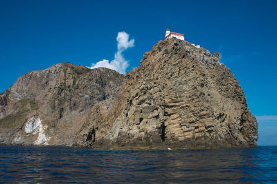 Scenic view of rocks in sea against blue sky