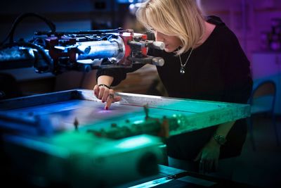 Businesswoman operating machinery at factory