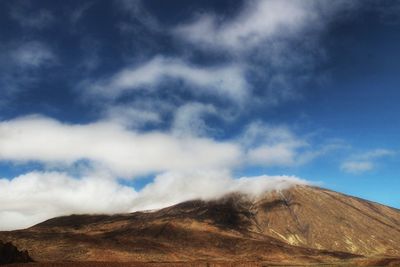 Low angle view of volcanic mountain against sky