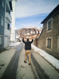 A man on the street with a hay basket