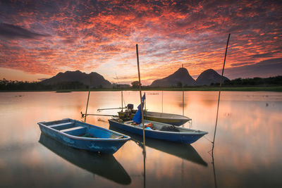 Boat moored on sea against sky during sunset