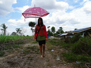 Full length of woman looking at cloudy sky