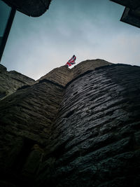 Low angle view of flag on mountain against sky