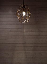 Low angle view of illuminated pendant light hanging on ceiling