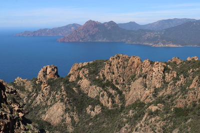 Scenic view of sea and mountains against sky