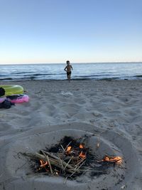 Boy on beach against clear sky