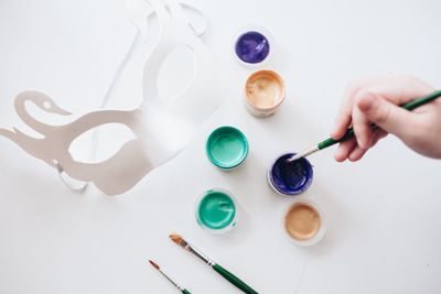 Cropped hand making mask at table