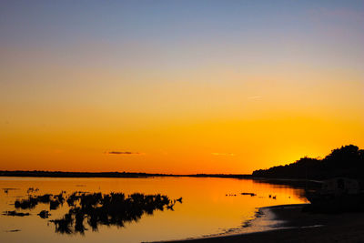 Scenic view of lake against orange sky