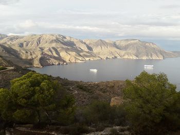 Scenic view of sea and mountains against sky