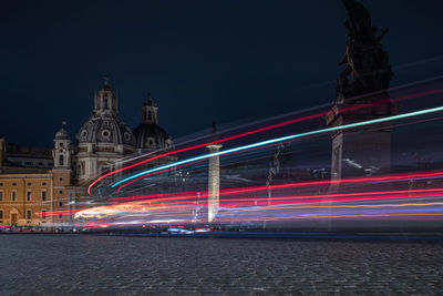 Light trails on illuminated city buildings at night