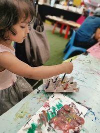 High angle view of cute girl painting on table