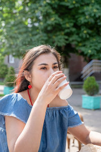 Young woman drinking coffee at street