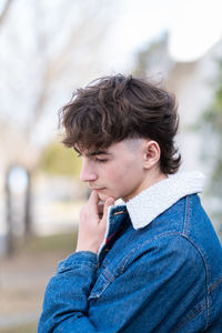 Portrait of teenager showing trendy haircut and denim jacket