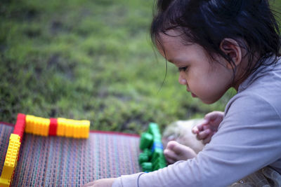 Side view of girl playing with toy on field