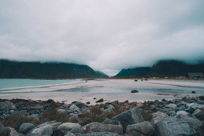 Scenic view of rocks on shore against sky