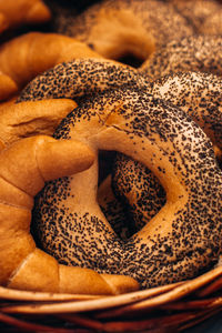 Fresh baked bread buns with poppy seeds in a wicker basket. bakery shop counter